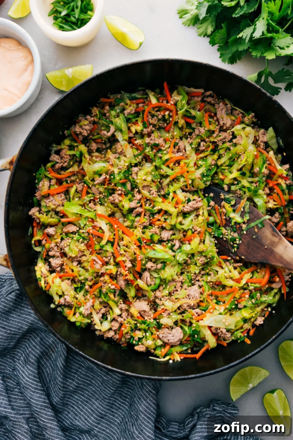 A delicious Ground Turkey Stir Fry cooking in a skillet, garnished with fresh sesame seeds and green onions, ready for serving.