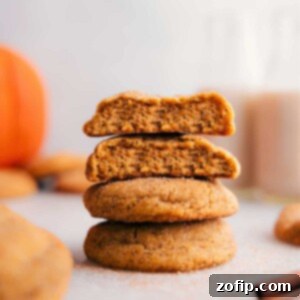 A stack of pumpkin snickerdoodles with one cookie split open, revealing the soft, moist center.