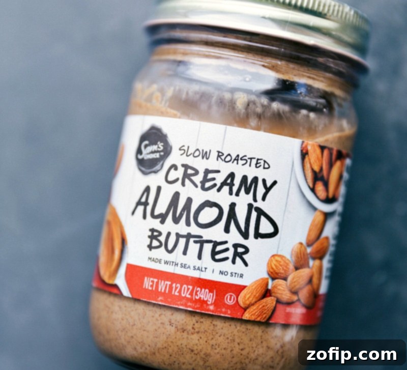 A jar of smooth, creamy almond butter, highlighting the preferred brand and texture for creating the best brownie batter overnight oats base.