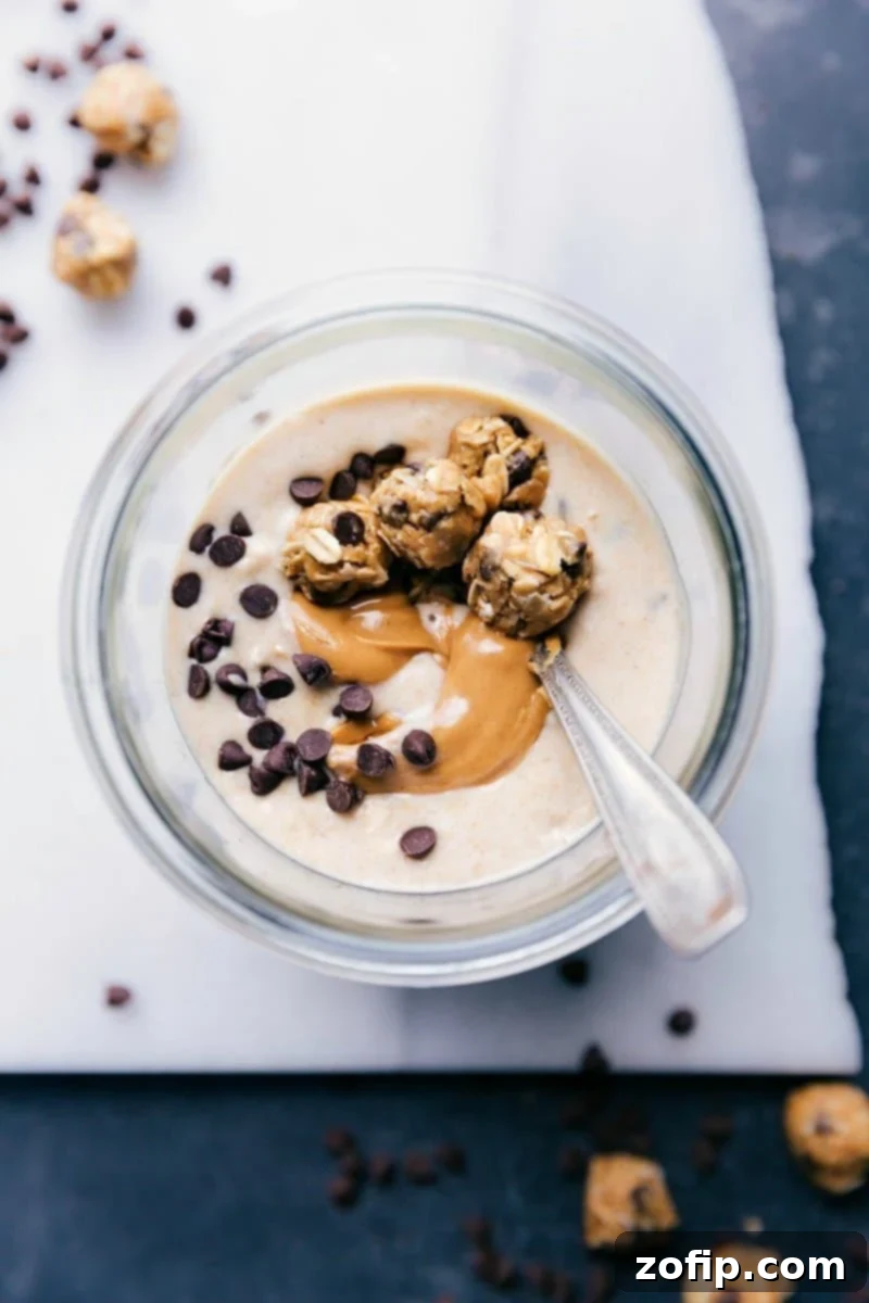 Creamy Peanut Butter Cookie Overnight Oats swirled with extra peanut butter and topped with miniature no-bake cookie dough balls, ready to be enjoyed as a healthy breakfast.