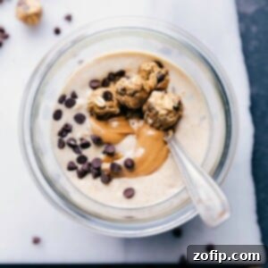 Peanut butter cookie overnight oats with a beautiful peanut butter swirl in it and mini cookie dough balls on top.
