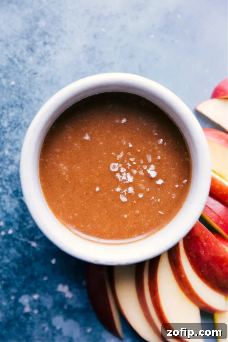 A bowl of rich, golden Healthy Caramel Sauce ready for serving, garnished with a sprinkle of sea salt.