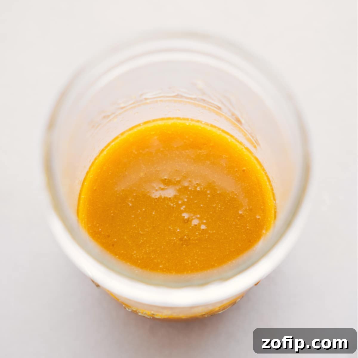 Close-up of the Apple-Dijon dressing being mixed in a mason jar.