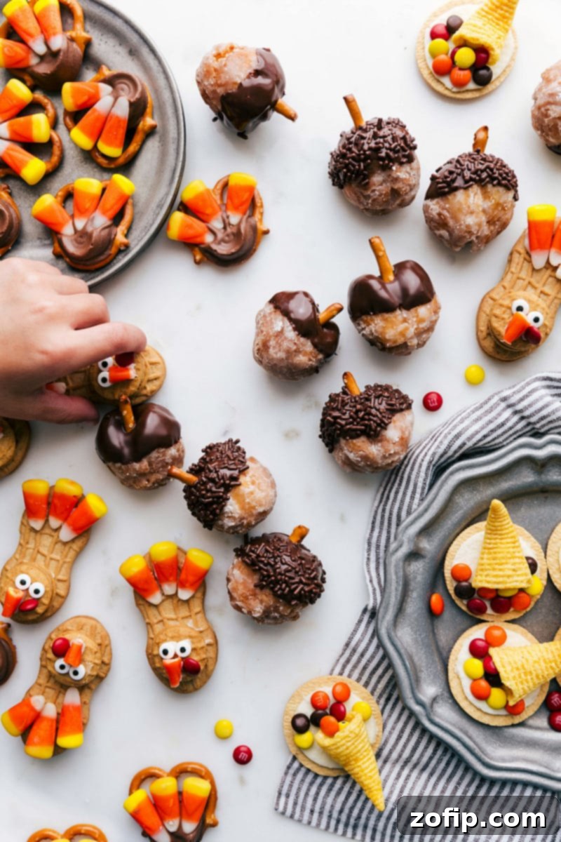 A festive board of various fall treats, featuring Acorn Donut Holes alongside Thanksgiving-themed cookies and candies, showcasing a delightful autumn spread.