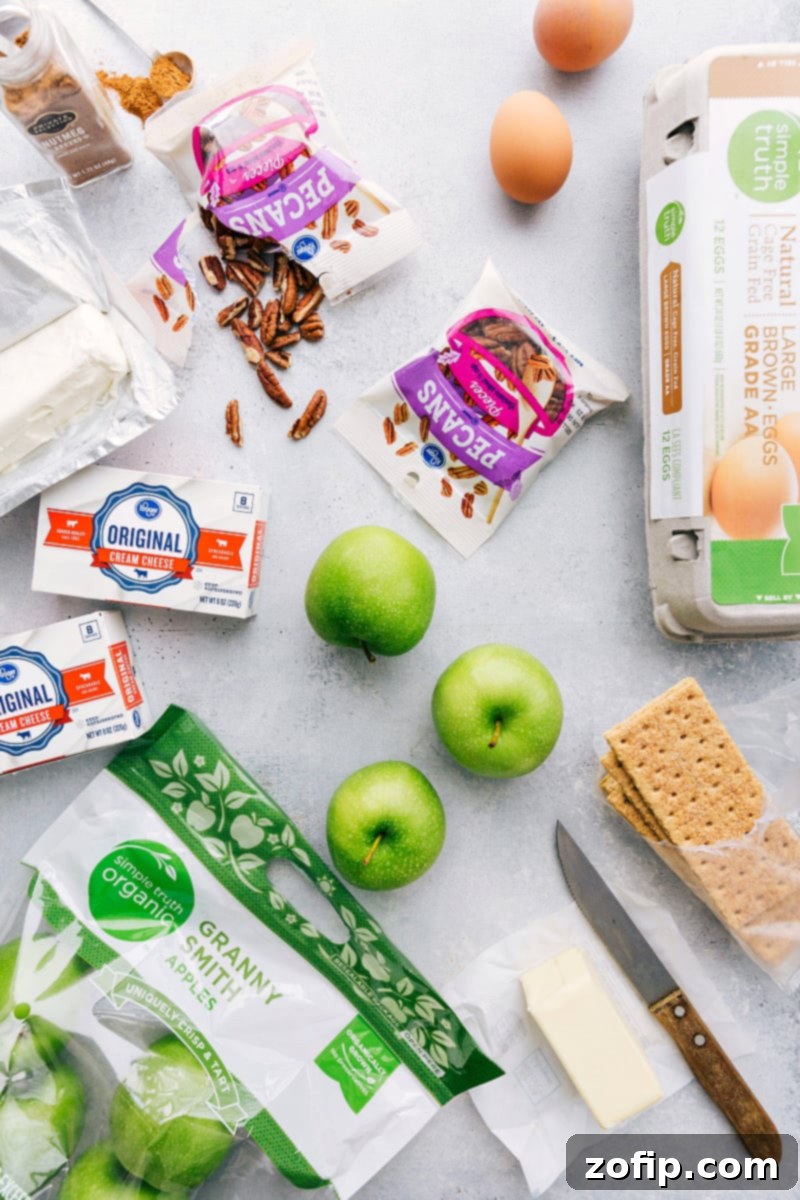 Key Ingredients for Caramel Apple Cheesecake Bars An array of fresh ingredients for making apple caramel cheesecake bars, including crisp apples, golden graham crackers, rich cream cheese, and various spices.
