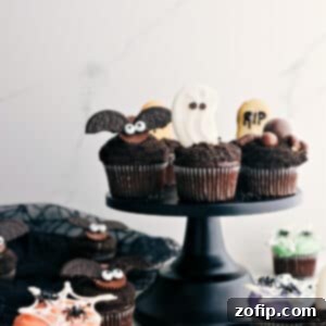 Spooktacular Halloween Cupcakes 3 Assortment of Halloween cupcakes, including a spiderweb, a bat, and a ghost, on a wooden board.
