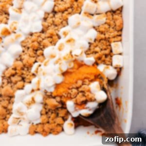 Maple Pecan Sweet Potato Casserole 3 Delicious Sweet Potato Casserole with double toppings of streusel and marshmallows, served in a white baking dish.