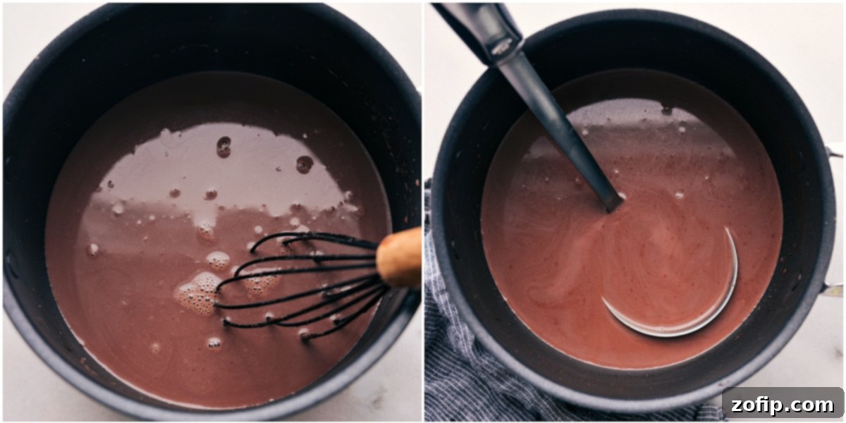 A close-up shot of hot chocolate simmering gently in a saucepan, being stirred with a whisk, showcasing its smooth, inviting texture as it warms to perfection before serving.