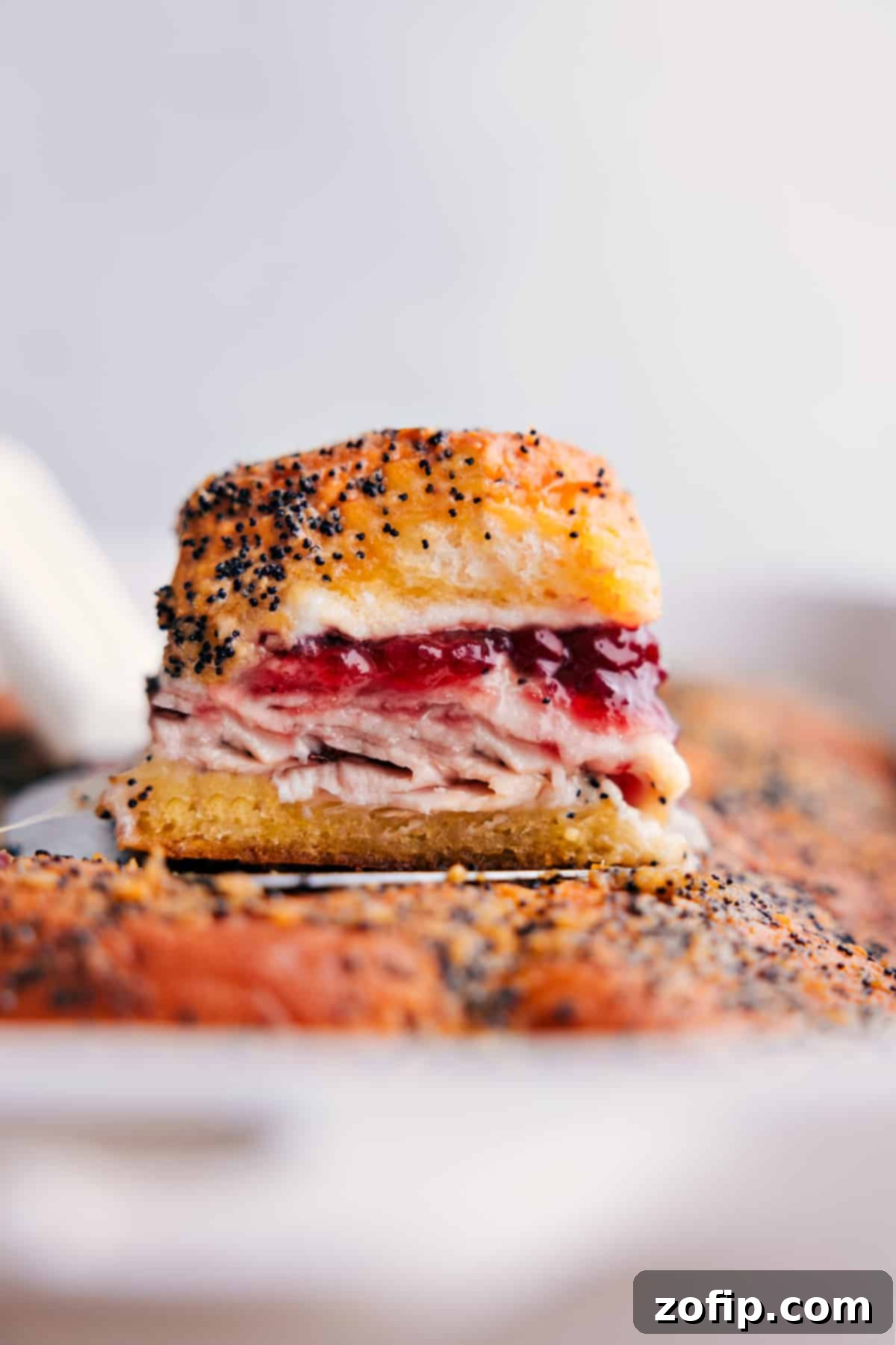 Stacked Turkey Cranberry Sliders on a serving platter, showcasing their golden-brown tops, melted cheese, and a hint of vibrant cranberry sauce, inviting you to enjoy.