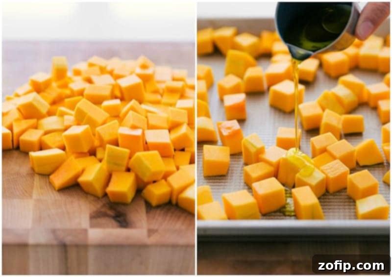 Butternut squash being chopped and coated in olive oil on a cutting board, ready for roasting.