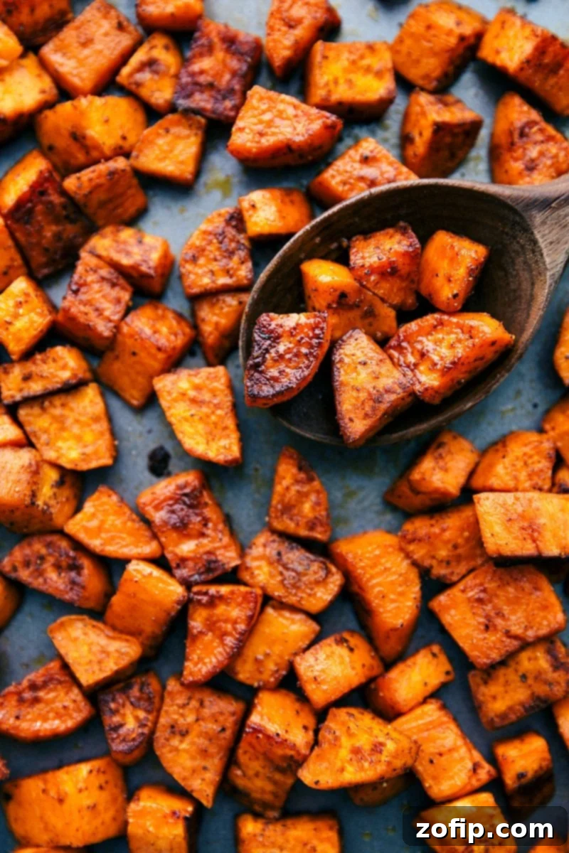 Finished batch of delicious roasted sweet potatoes resting on a sheet pan, ready to be served