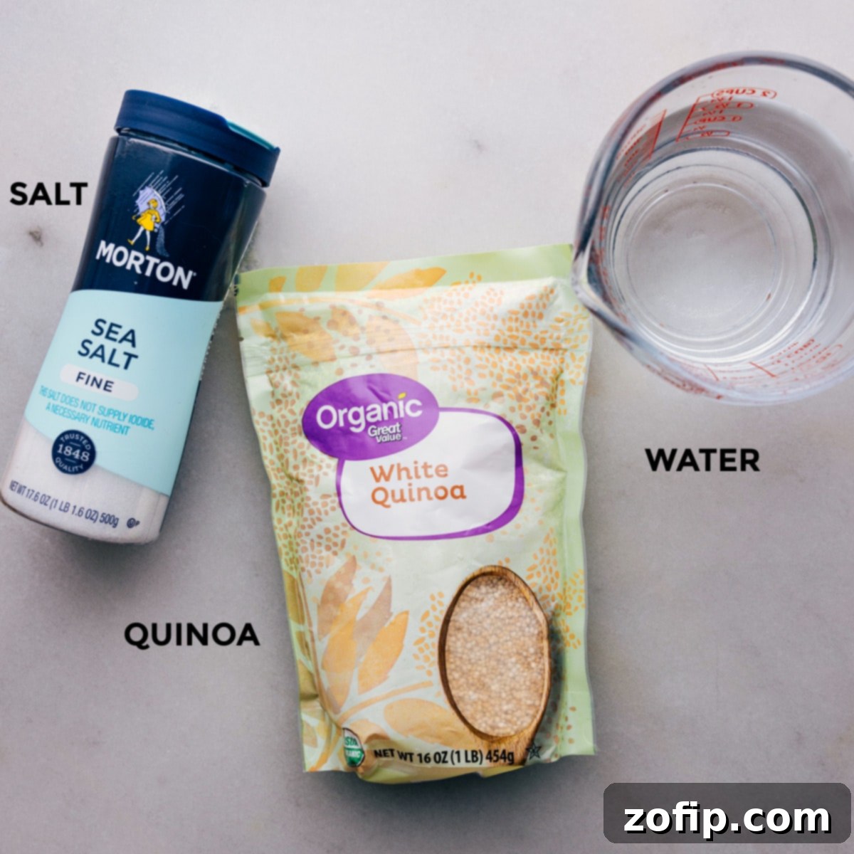 All the essential ingredients for cooking quinoa laid out neatly: quinoa, water, and salt.