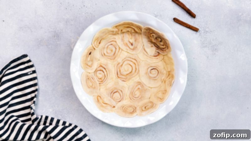 Process image demonstrating how to create the cinnamon roll crust from store-bought pie dough, showing the rolled dough being sliced.