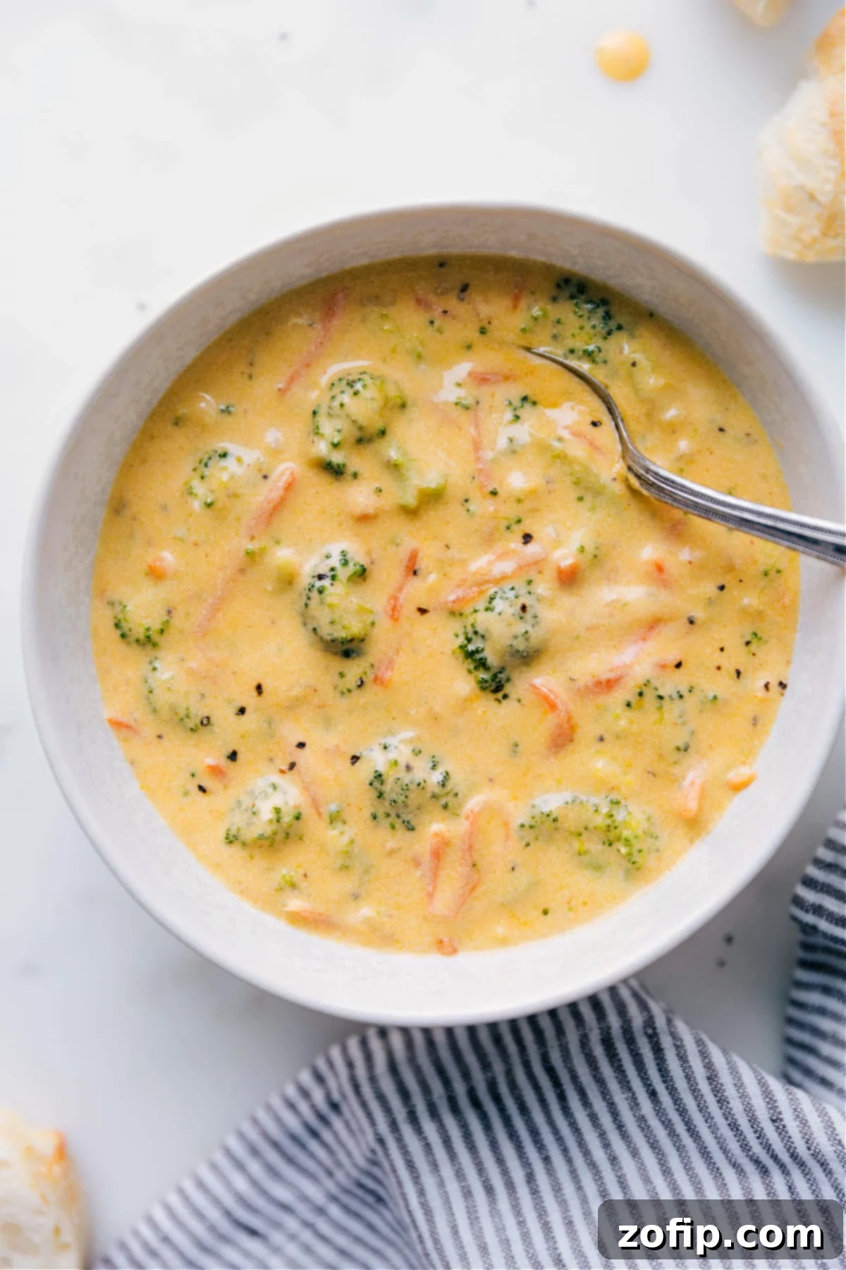 A steaming bowl of homemade Broccoli Cheddar Soup, garnished with fresh parsley and shredded cheddar, ready to be enjoyed.