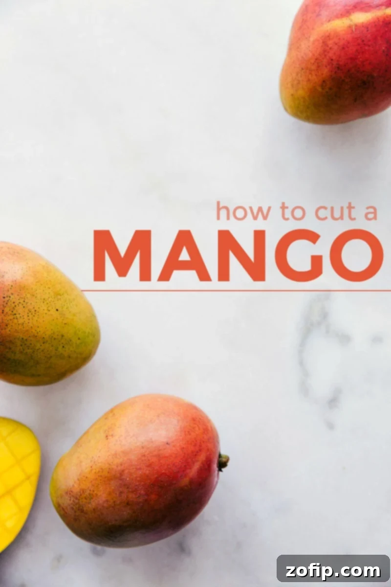 Ripe mangoes on a marble cutting board, with a knife and cut mango pieces, illustrating "how to cut a mango" in a visual guide.