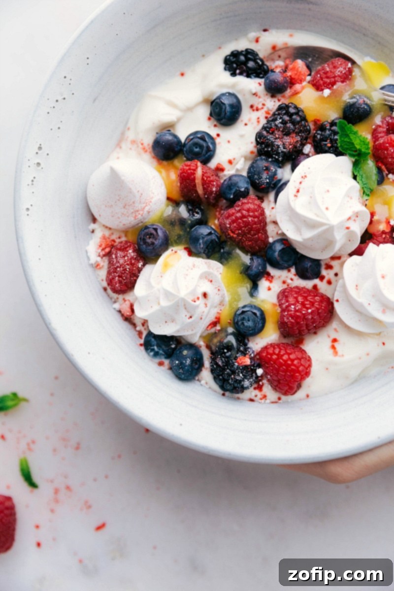 A bowl of Meringue Cookies served with creamy yogurt, fresh berries, and luscious lemon curd, ready to be enjoyed.