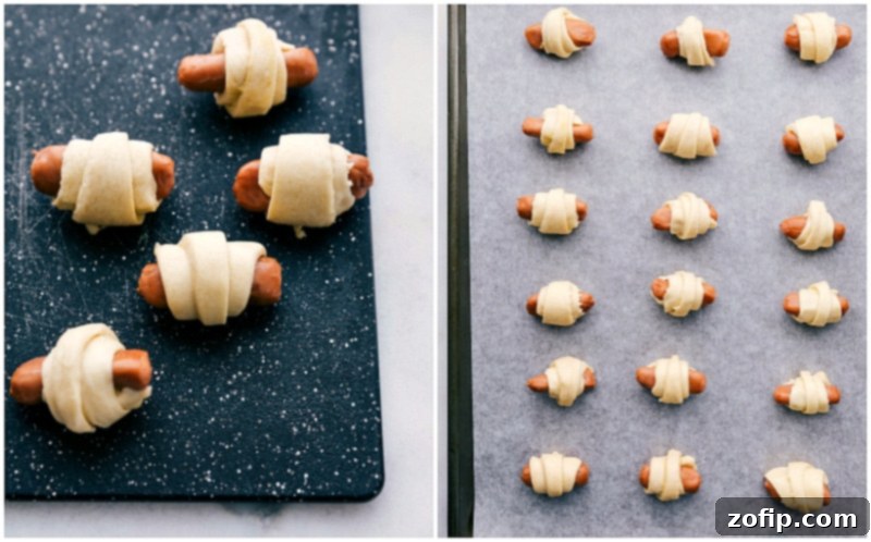 Sausages wrapped in crescent dough and arranged neatly on a parchment-lined baking sheet.