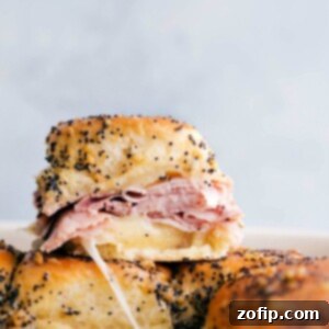 Ham and cheese sliders stacked on top of each other showing the delicious inside.