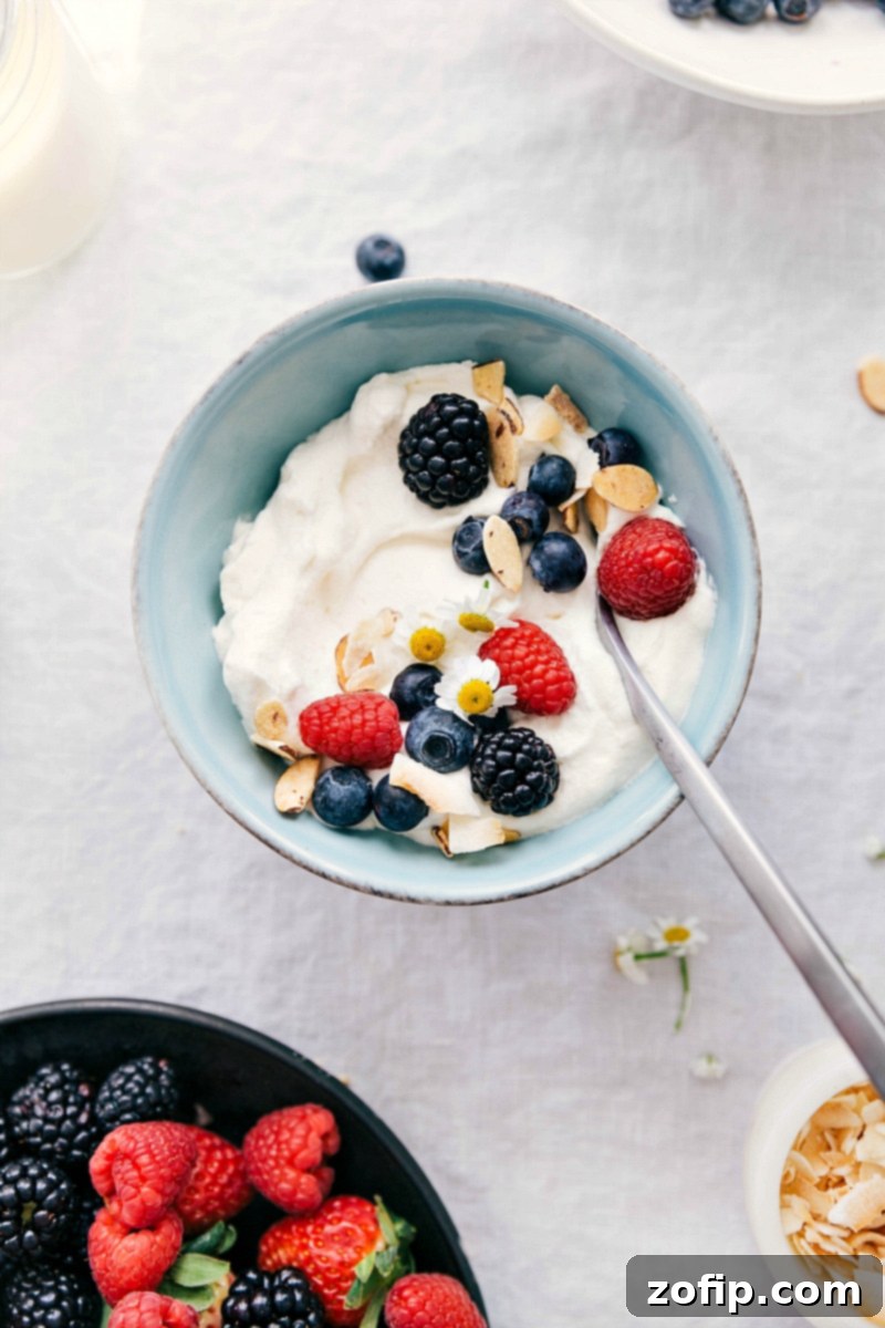 Learn how to make whipped cream from scratch with only 3 ingredients: heavy whipping cream, powdered sugar, and vanilla. It's so easy and delicious! A serving of homemade whipped cream generously topped with fresh berries and chopped nuts, showcasing its versatility.