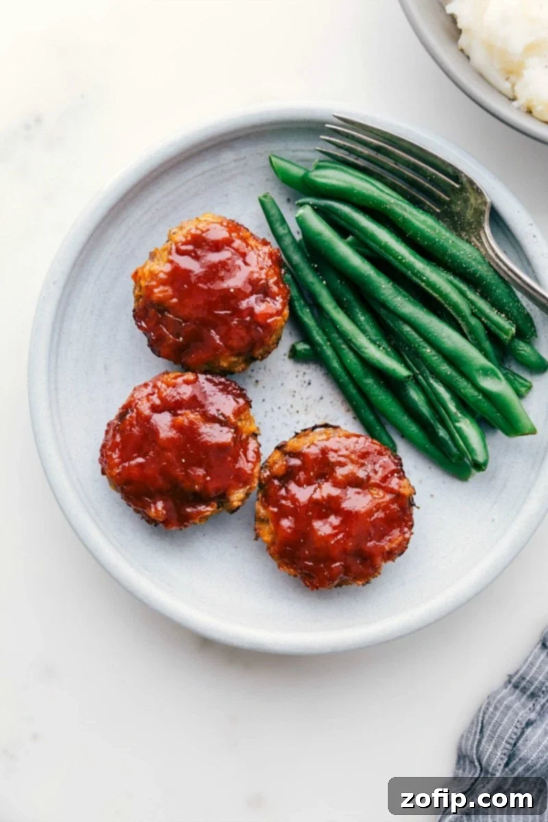 Ready-to-eat mini turkey meatloaves next to vibrant green beans, showcasing a healthy and delicious meal.