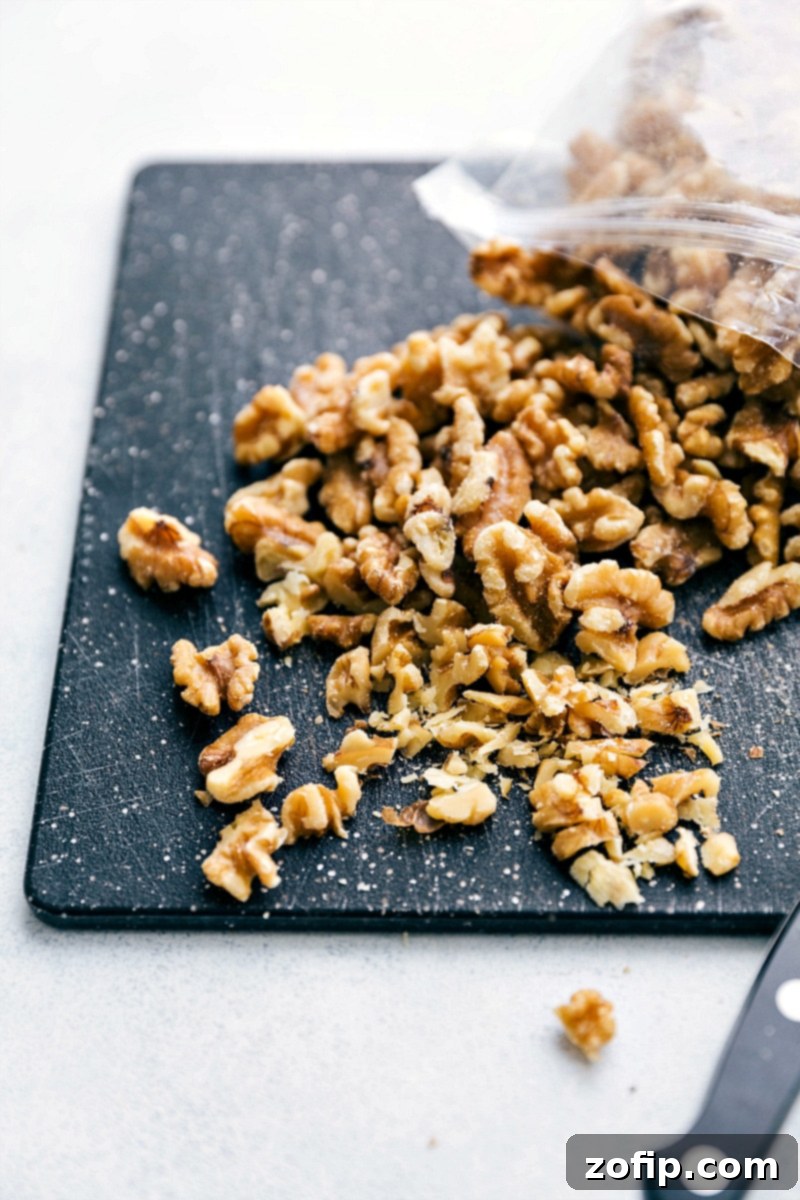 Close-up photo of walnuts being finely chopped on a wooden cutting board, preparing them as a key ingredient for Banana Crepes. The texture and freshness of the nuts are clearly visible, promising a delightful crunch.