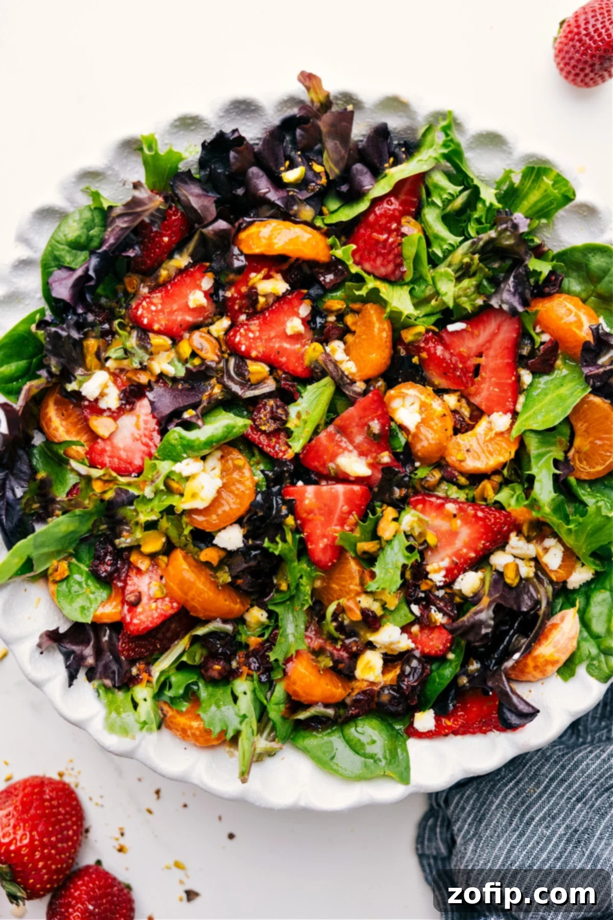 Freshly mixed Strawberry Salad topped with a vibrant citrus dressing, ready to be served and enjoyed.