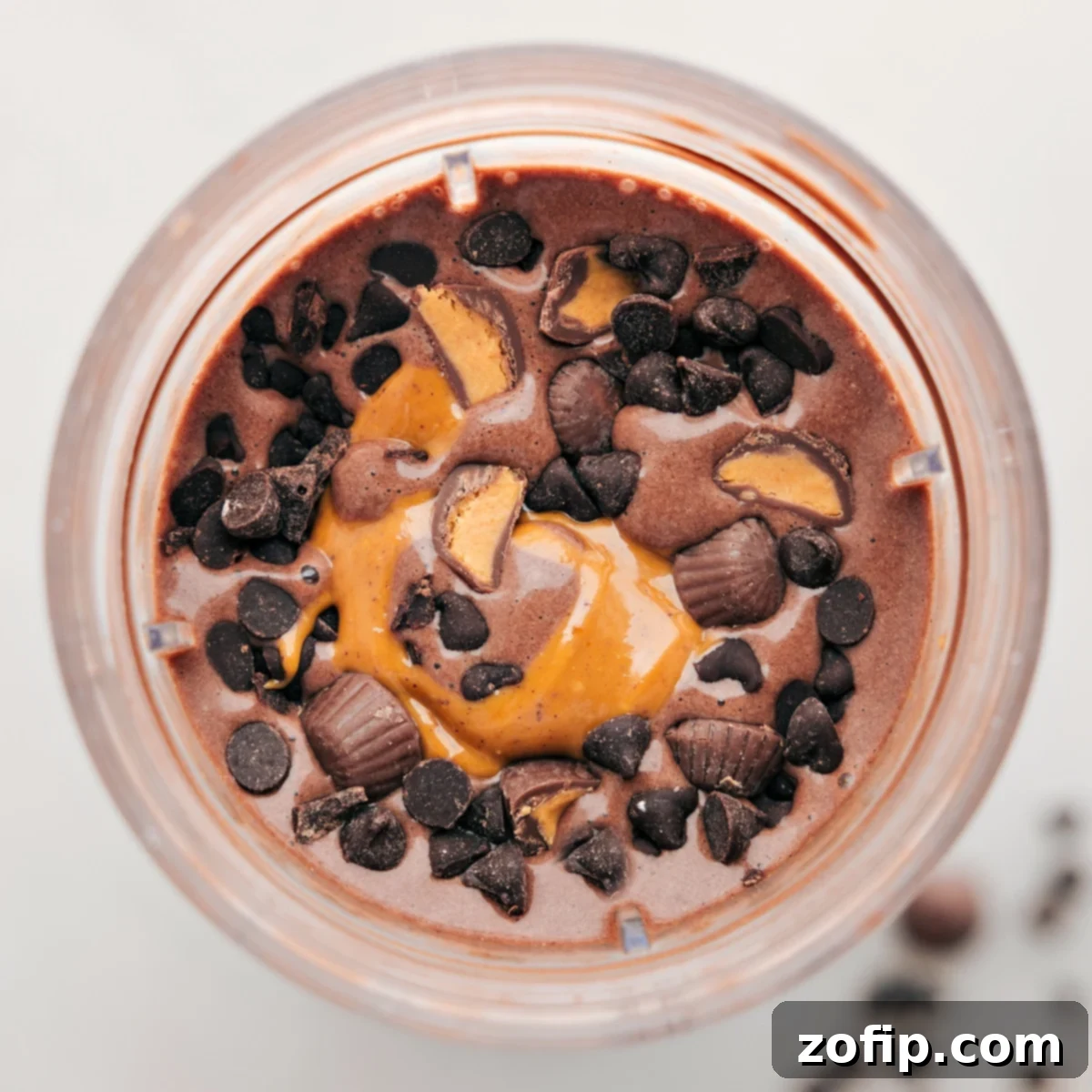 Chocolate Peanut Butter Protein Shake Mix-Ins Chocolate peanut butter protein shake with fun toppings like chocolate chips and Reese's pieces, offering a high-protein indulgence.
