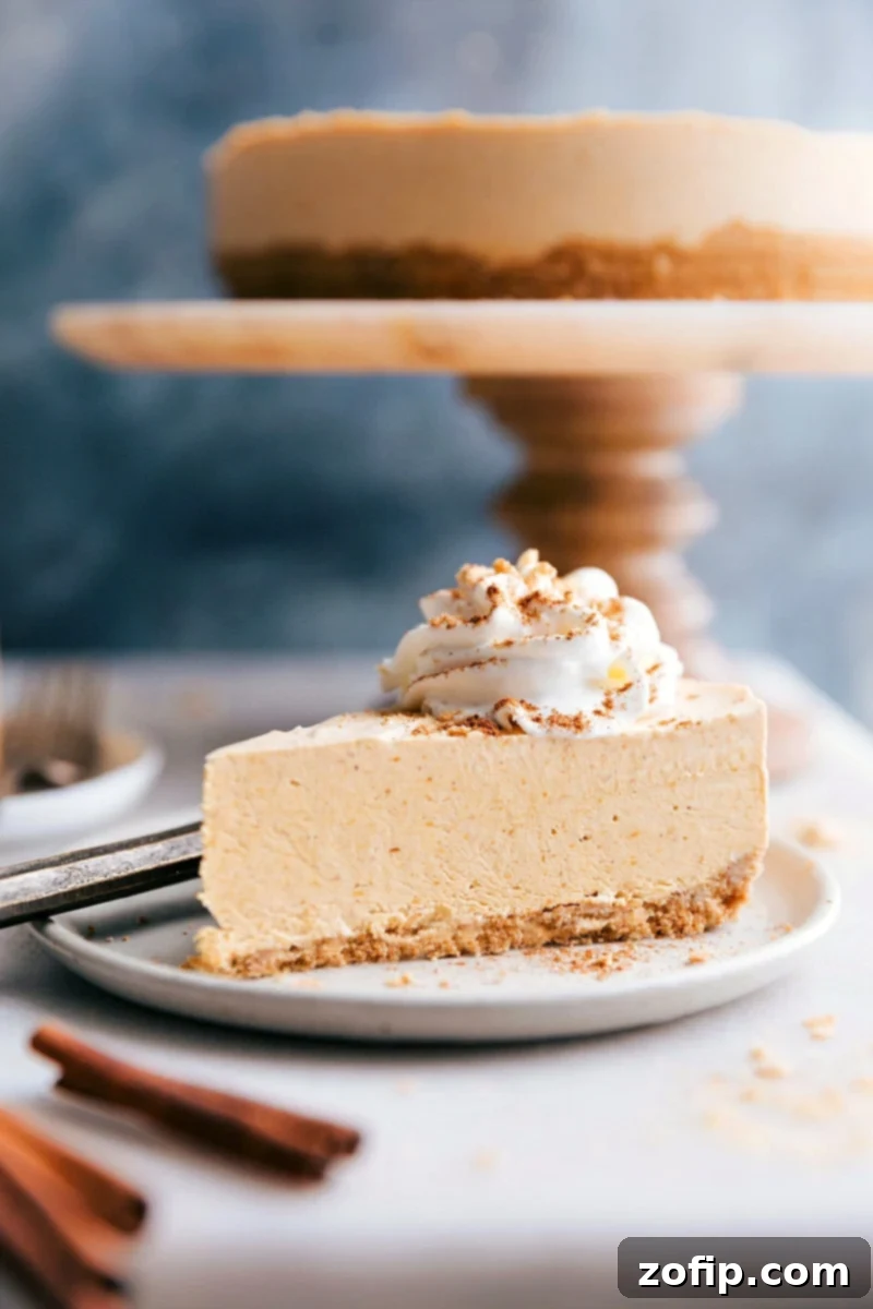 Indulgent Slice of No-Bake Pumpkin Cheesecake A tempting slice of no-bake pumpkin cheesecake with the whole cheesecake in the background, ready to be savored, topped with whipped cream and a sprinkle of cinnamon.
