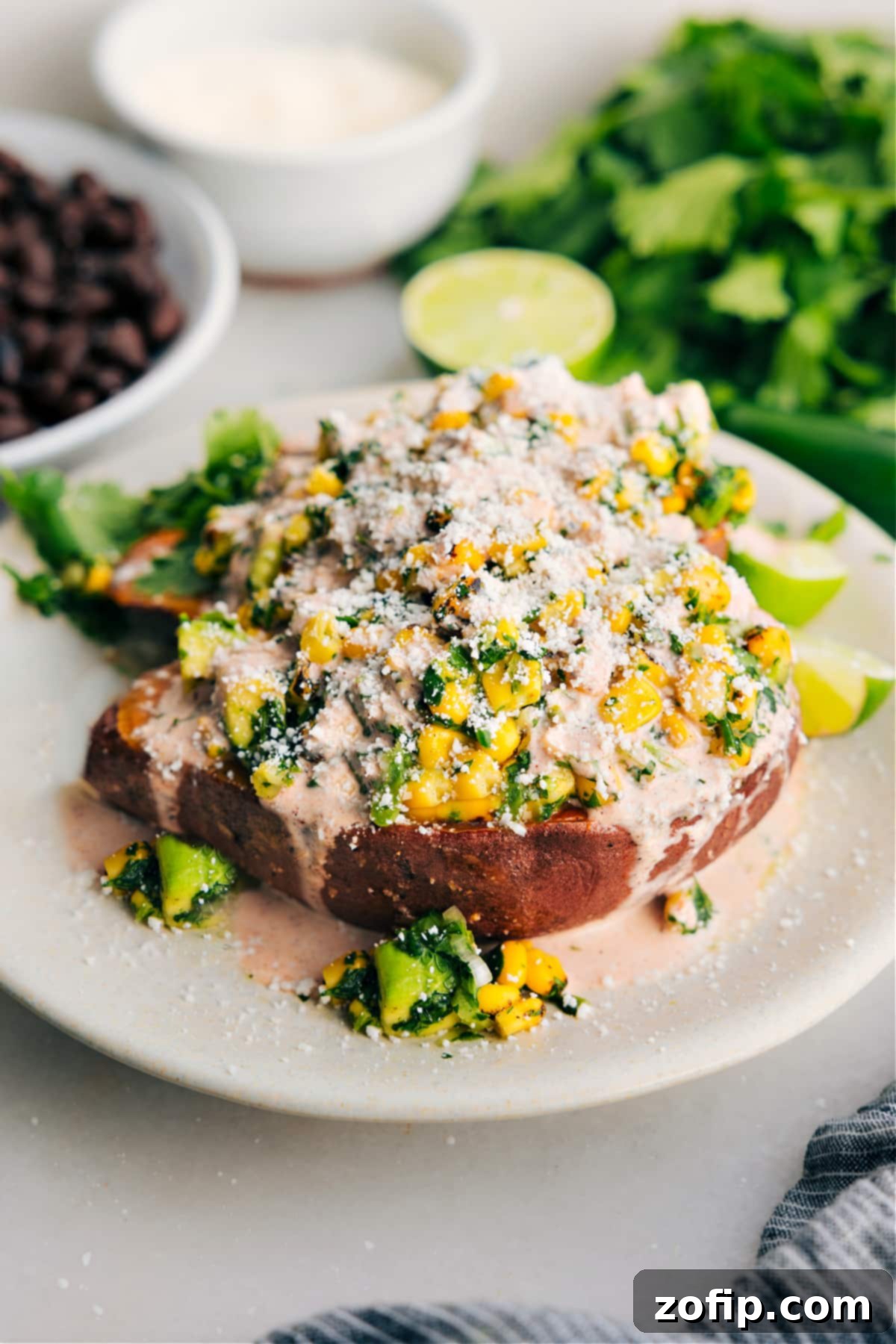Delicious Mexican street corn loaded sweet potatoes topped with a creamy sauce and Cotija cheese.