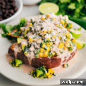 A perfectly loaded sweet potato, garnished with fresh cilantro and a lime wedge, ready to be enjoyed.