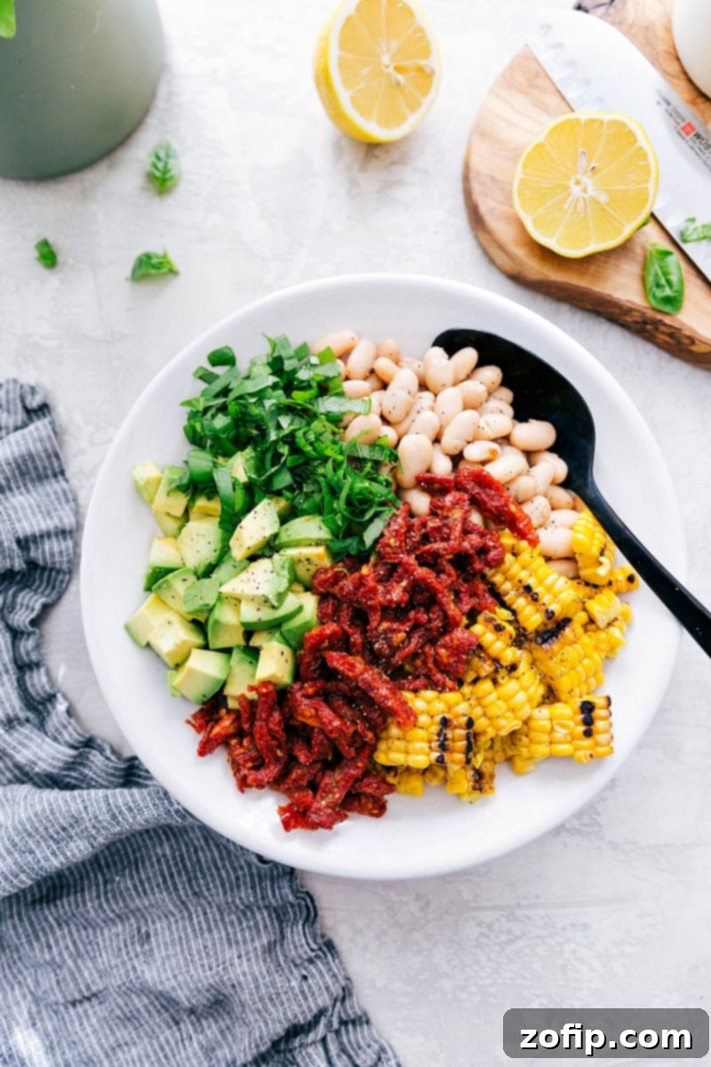 This White Bean Salsa with creamy avocado, crisp corn, savory sun-dried tomatoes, fresh lemon, and sweet basil is our latest obsession! It's perfect over grilled Pesto Chicken, quinoa, or couscous (hello crave-able vegetarian meal!), or with some good tortilla chips. Recipe via Chelseasmessyapron #healthy #keto #whole #protein #whole30 #best #avocado #corn #sundriedtomatoes #clean #cleaneating #whitebean #salsa Fresh ingredients for White Bean Salsa including white beans, corn, avocado, sun-dried tomatoes, and basil
