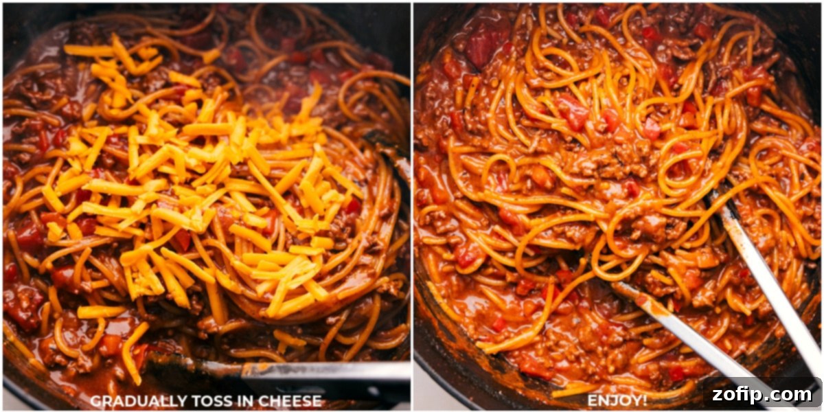 Grated cheddar cheese being tossed into the hot Taco Spaghetti until melted and creamy.