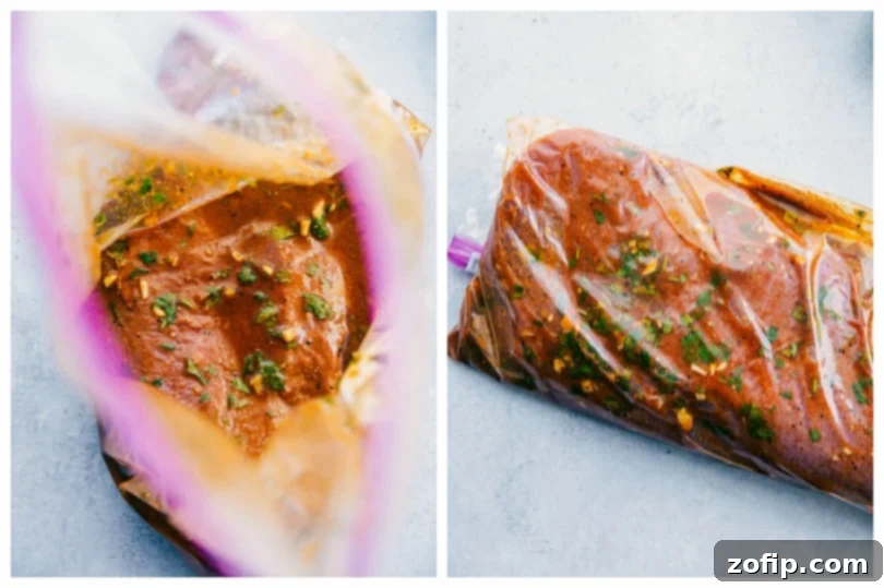 Steak marinating in a sealable bag with fresh herbs and citrus slices.