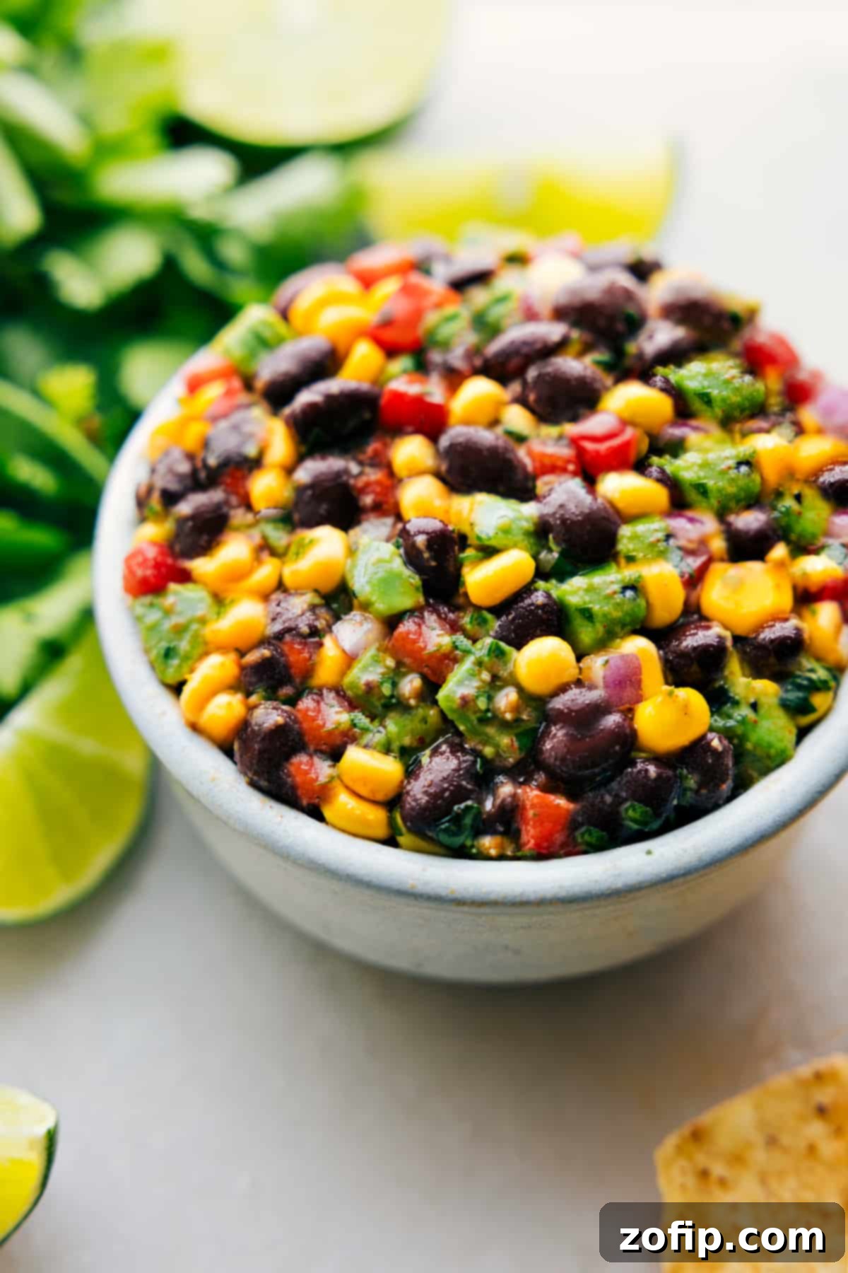 A vibrant bowl of Black Bean Corn Avocado Salad, showcasing black beans, corn, diced avocado, and red bell pepper, ready to be enjoyed as a refreshing meal or side dish.