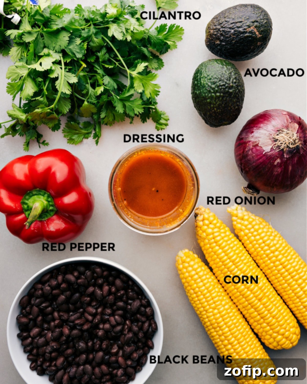 All the fresh ingredients for Black Bean Corn Avocado Salad prepped and laid out, including canned black beans, fresh corn, diced red bell pepper, and cilantro, ready for easy assembly.
