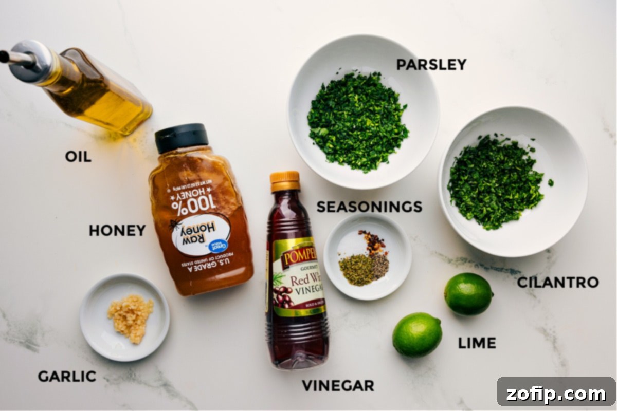 Fresh ingredients prepped for making chimichurri chicken, including olive oil, honey, minced garlic, a selection of vibrant seasonings, fresh parsley and cilantro, bright limes, and red wine vinegar.