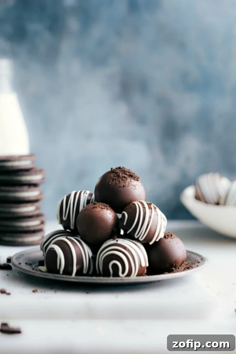 Oreo Balls, piled up on a plate, showcasing their inviting chocolate coating and decorative drizzles.
