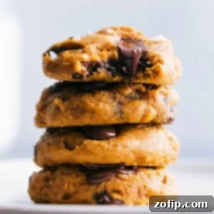 A stack of freshly baked pumpkin cookies, made from a cake mix, with a golden hue and visible chocolate chips, presented for serving.