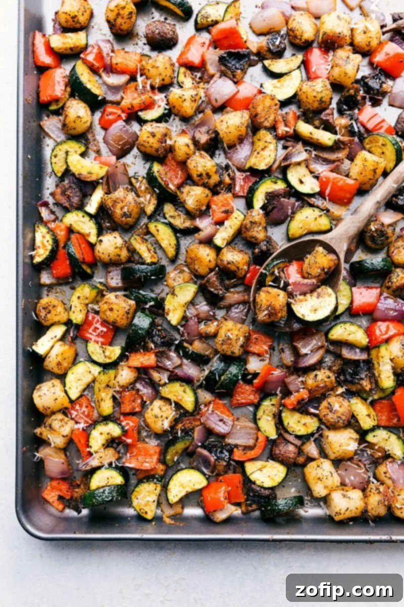 A perfectly cooked plate of baked gnocchi and roasted vegetables, garnished with fresh herbs and a generous sprinkle of Parmesan cheese, elegantly plated and ready to be enjoyed.