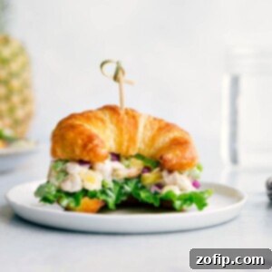 Pineapple chicken salad on a croissant, overflowing with flavorful ingredients, creating the perfect combination of savory and sweet.