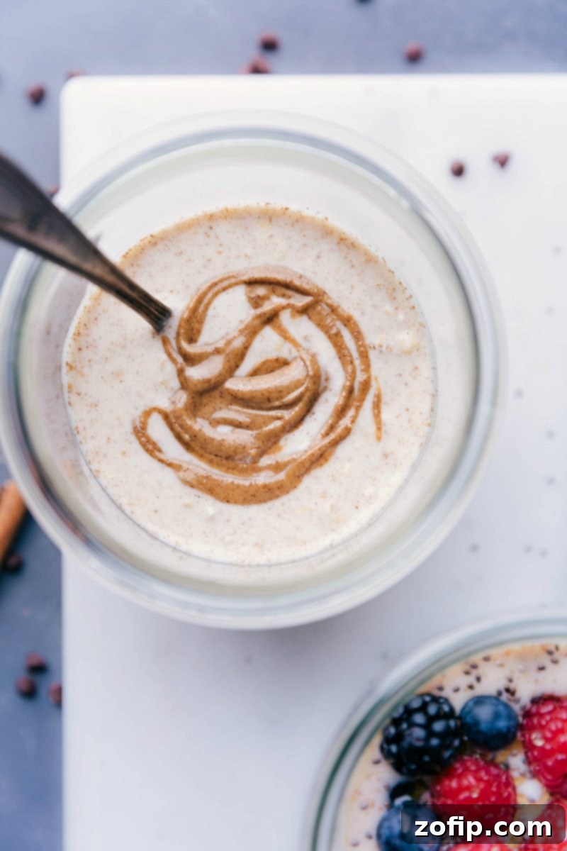 Base recipe for overnight oats in a bowl, with almond butter beautifully swirled into it, ready to be customized.