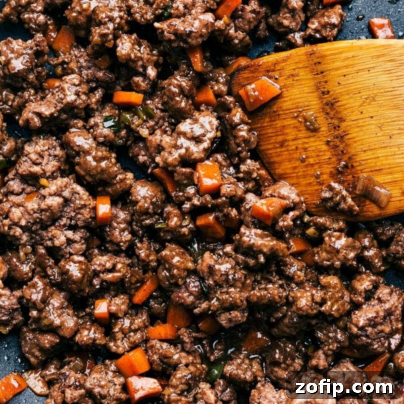 Cooked ground beef with carrots used in Asian-style beef lettuce wraps, ready to be wrapped in lettuce leaves.