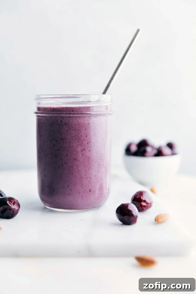 A delicious cherry smoothie with a straw in it, showcasing a vibrant color and smooth texture, ready to be enjoyed.