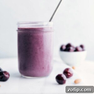 A delicious cherry smoothie with a straw in it, showcasing a vibrant color and smooth texture.