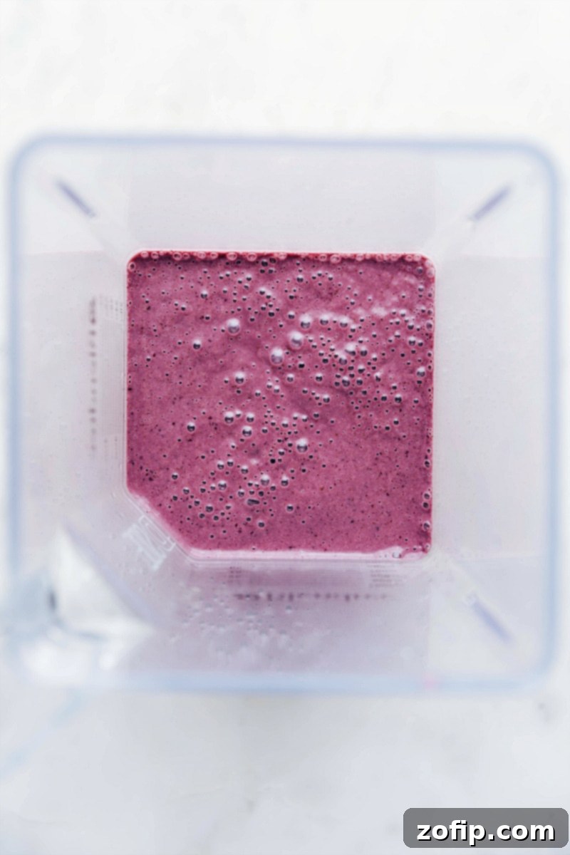 All the ingredients for the cherry smoothie blended together to create a smooth and delicious texture, poured into a glass.