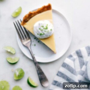 Slice of creamy key lime pie with a dollop of whipped cream on top, ready to be served.