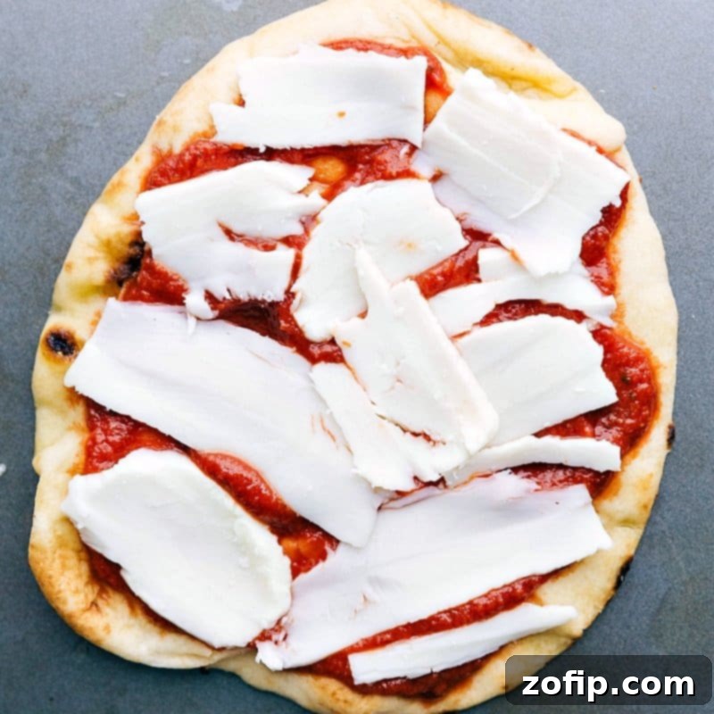 Chunks of fresh mozzarella cheese being added on top of the sauce.