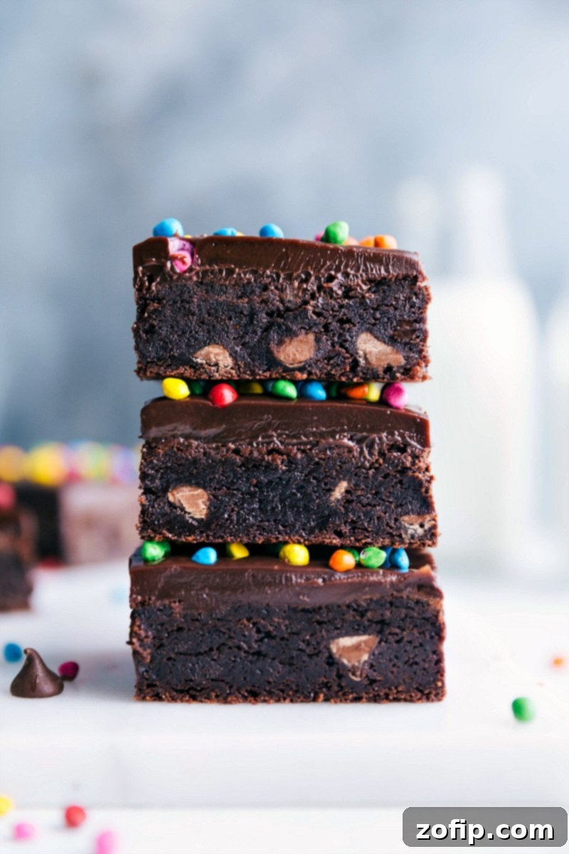 Homemade cosmic brownies stacked, showcasing its delicious layers, and topped with colorful candies - a nostalgic and delicious treat.