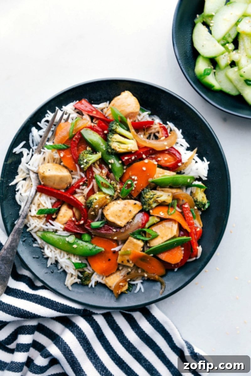 Flavor-packed stir fry chicken served in a bowl over a bed of rice, ready to be enjoyed.
