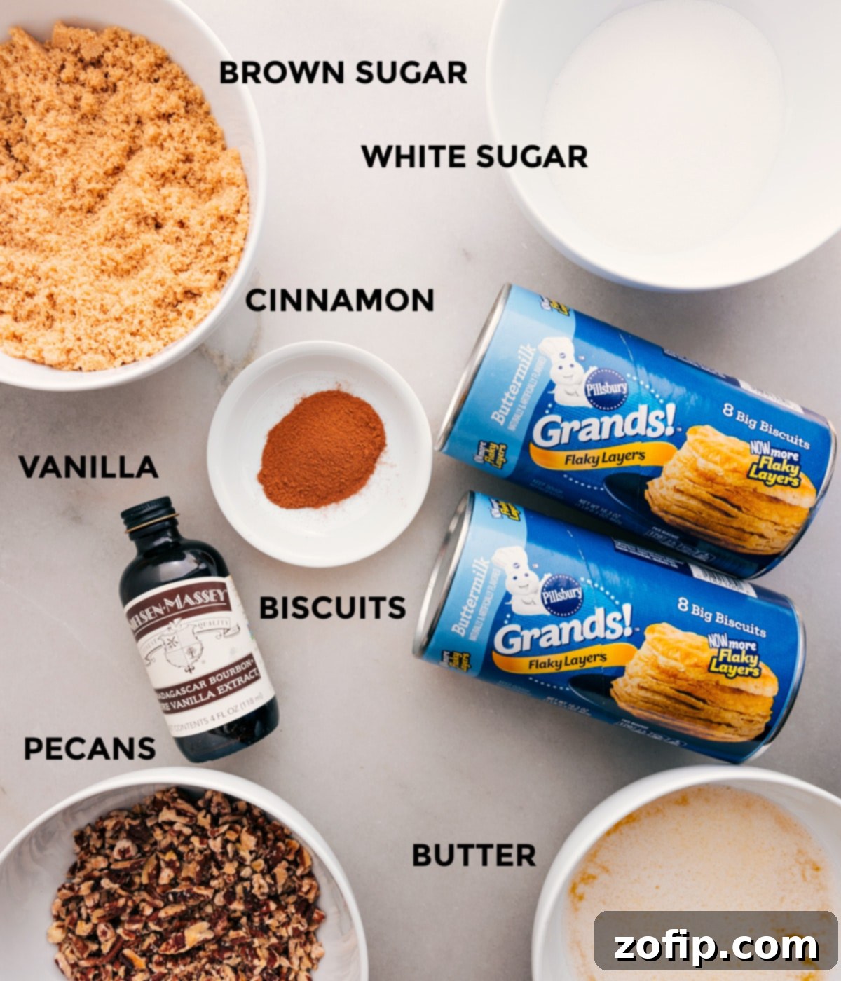 Ingredients In Monkey Bread Recipe All the essential ingredients for Monkey Bread are meticulously prepped and laid out for easy assembly: an assortment of sugars, fragrant cinnamon, ready-to-use biscuit dough, pure vanilla extract, crunchy pecans, and creamy butter.